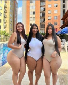 three women are posing for a picture in a city