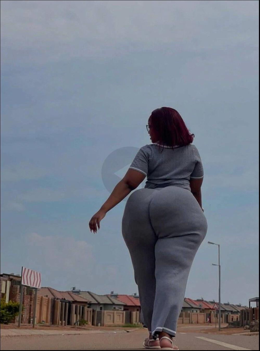 a woman is walking down the street with a skateboard