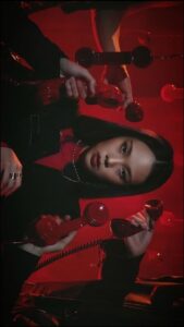 a woman is drinking a glass of red wine