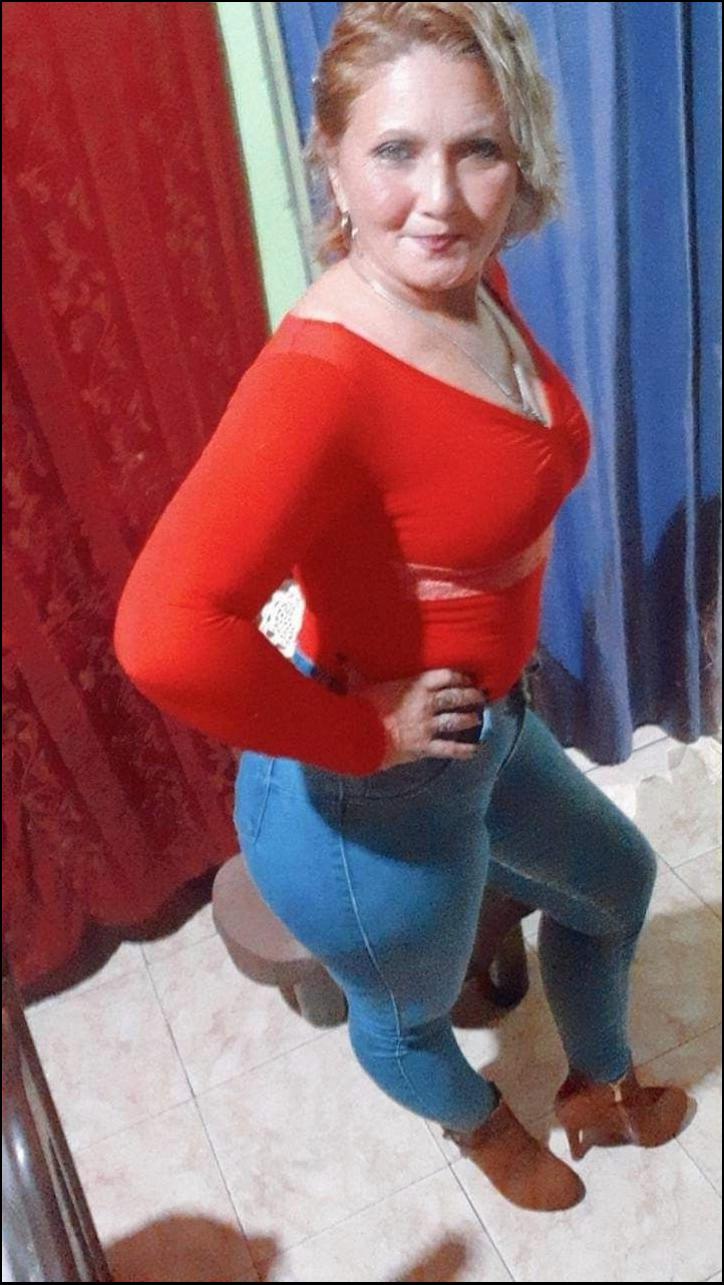 a young woman standing in front of a red wall