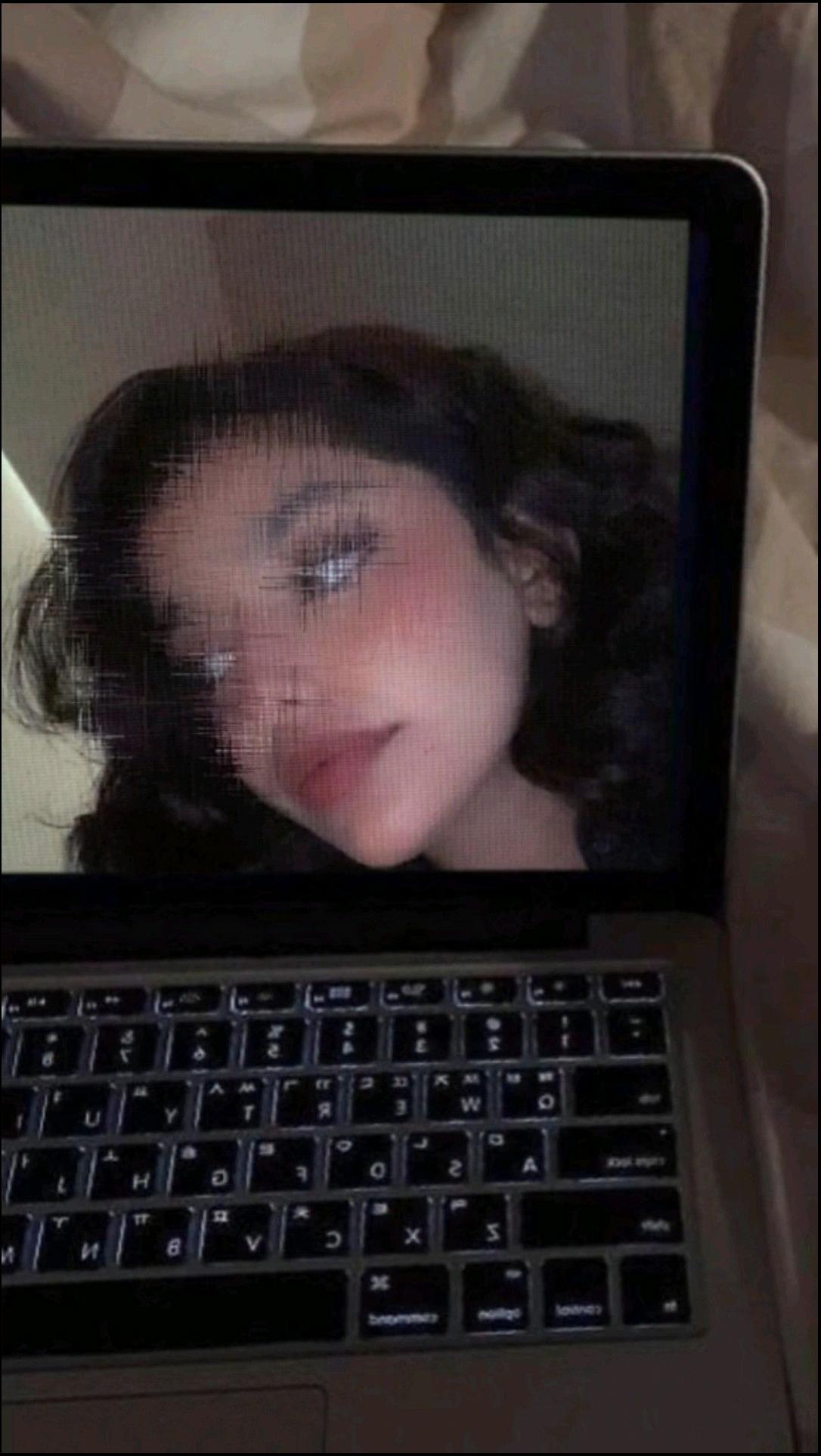 a woman is looking at a laptop on a desk