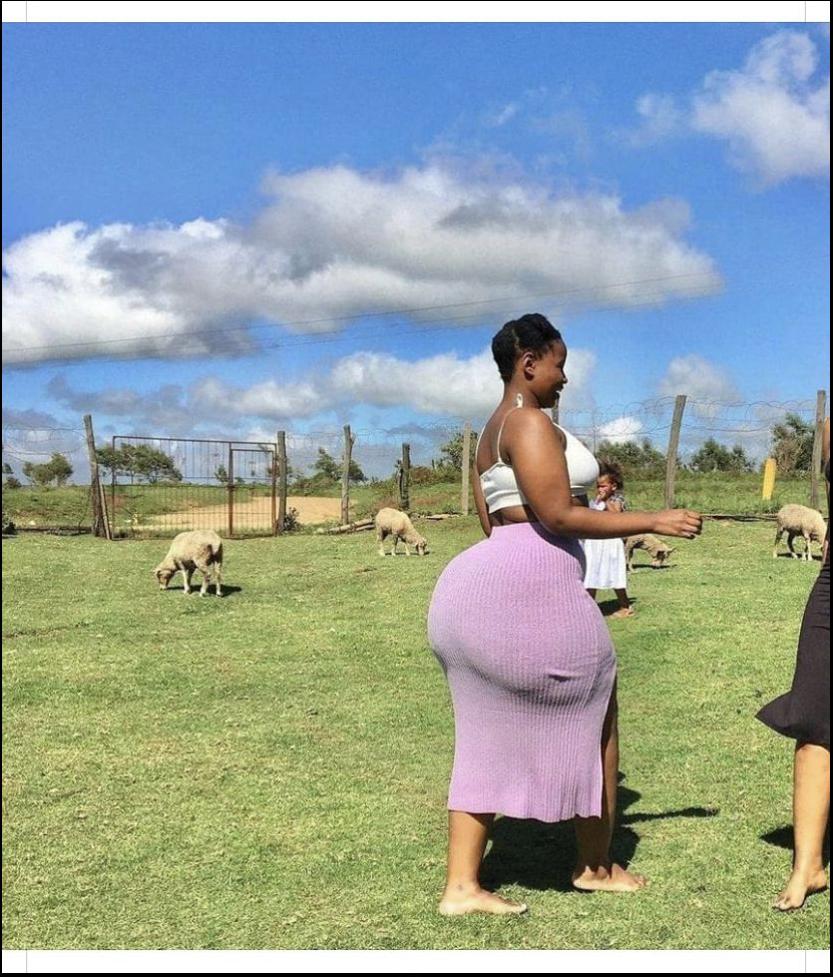 a woman is standing in a field with a stuffed animal