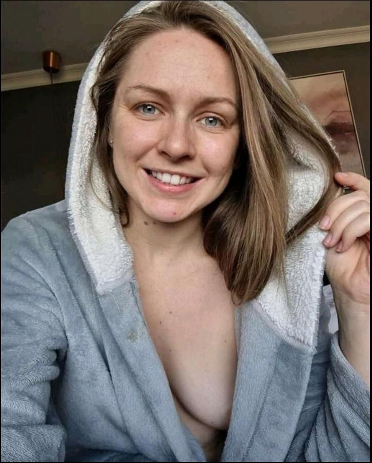 a woman is smiling while holding a white towel