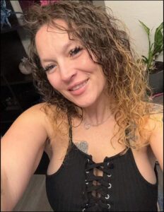 a woman with a black hair and a red tie