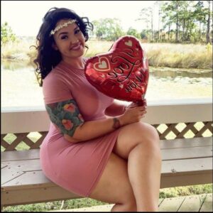 a woman sitting on a bench wearing a red and white striped shirt
