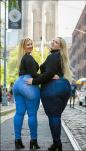 two women are standing on a sidewalk with a street sign