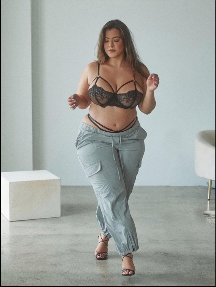 a woman in a black dress is standing on a floor