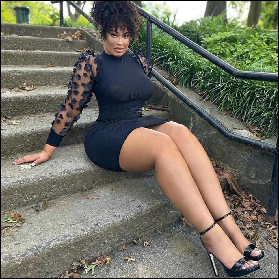 a woman is sitting on a cement wall