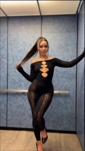 a woman in a black dress holding a black skateboard