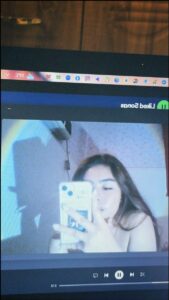 a woman is holding a laptop and a tv