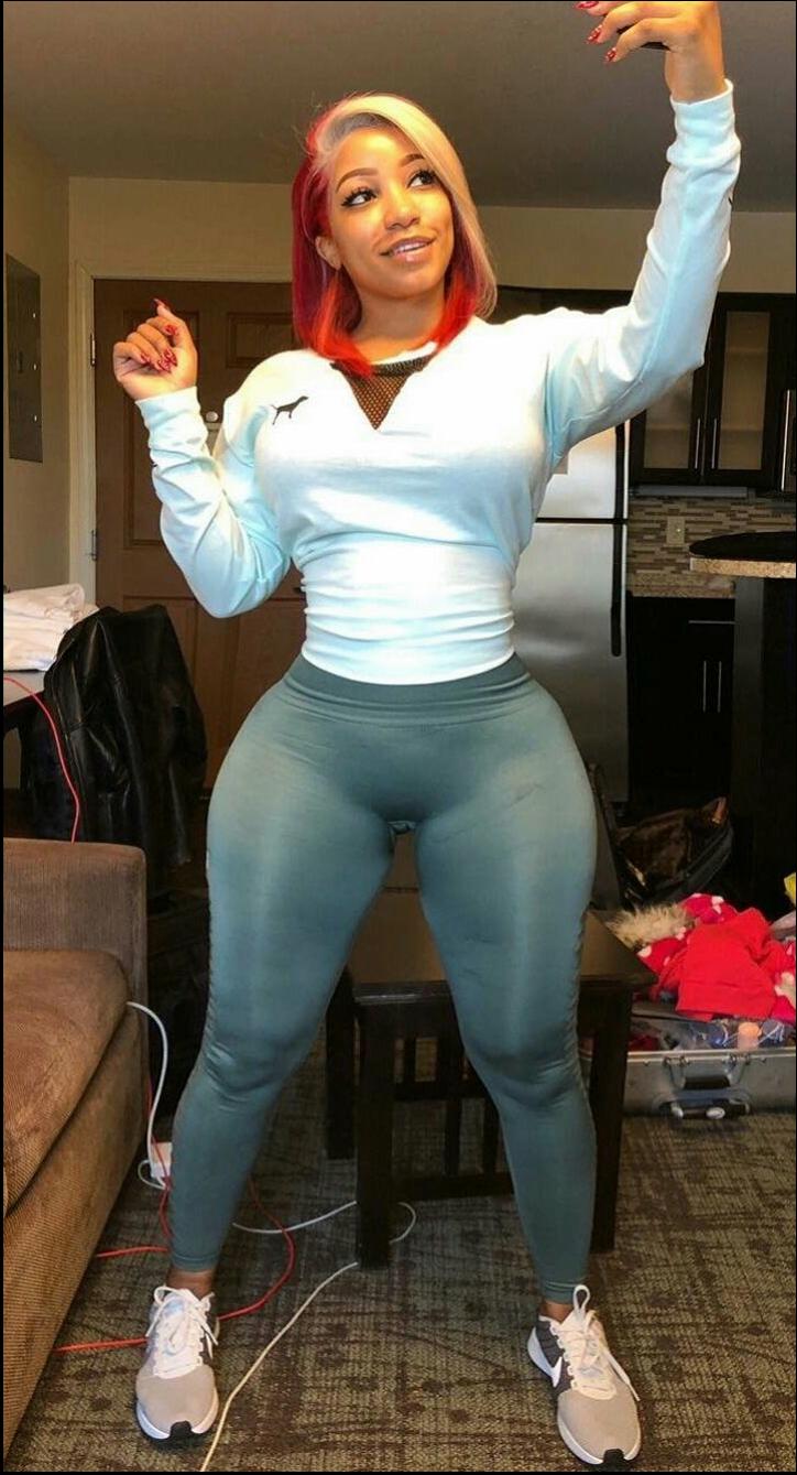 a woman is standing on a couch with a remote