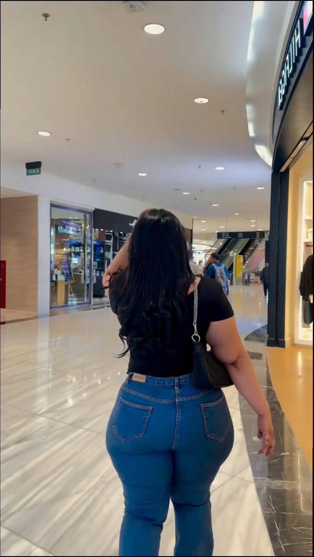 a woman is standing in a lobby with a suitcase