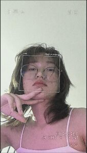 a woman is brushing her teeth with a pink brush