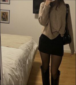 a woman is standing in a bed with a phone