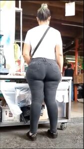 a woman is standing on a sidewalk with a cell phone