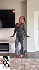 a woman in a black dress standing in front of a stove