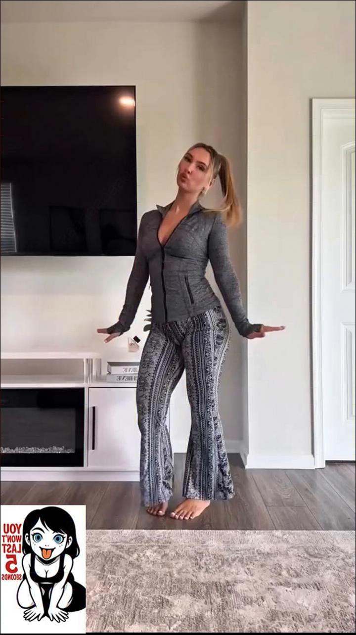 a woman in a black dress standing in front of a stove