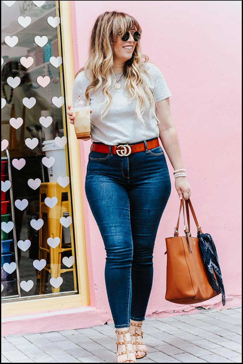 a woman standing in front of a wall with a suitcase