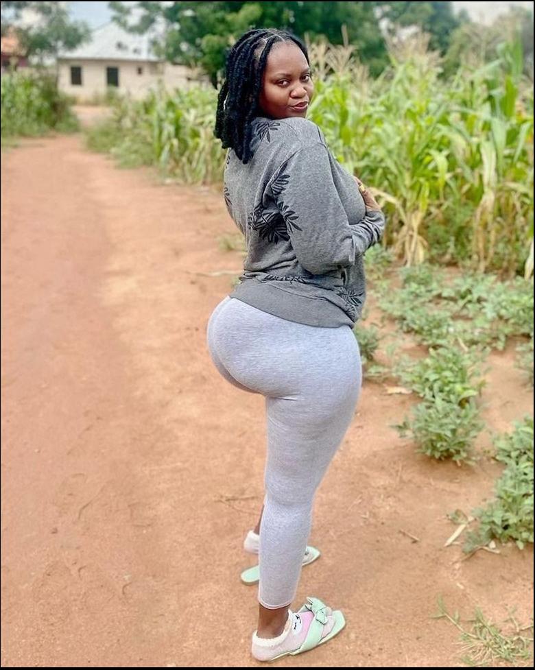 a woman is standing on a dirt road