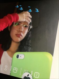 a woman holding a cell phone in front of a wall