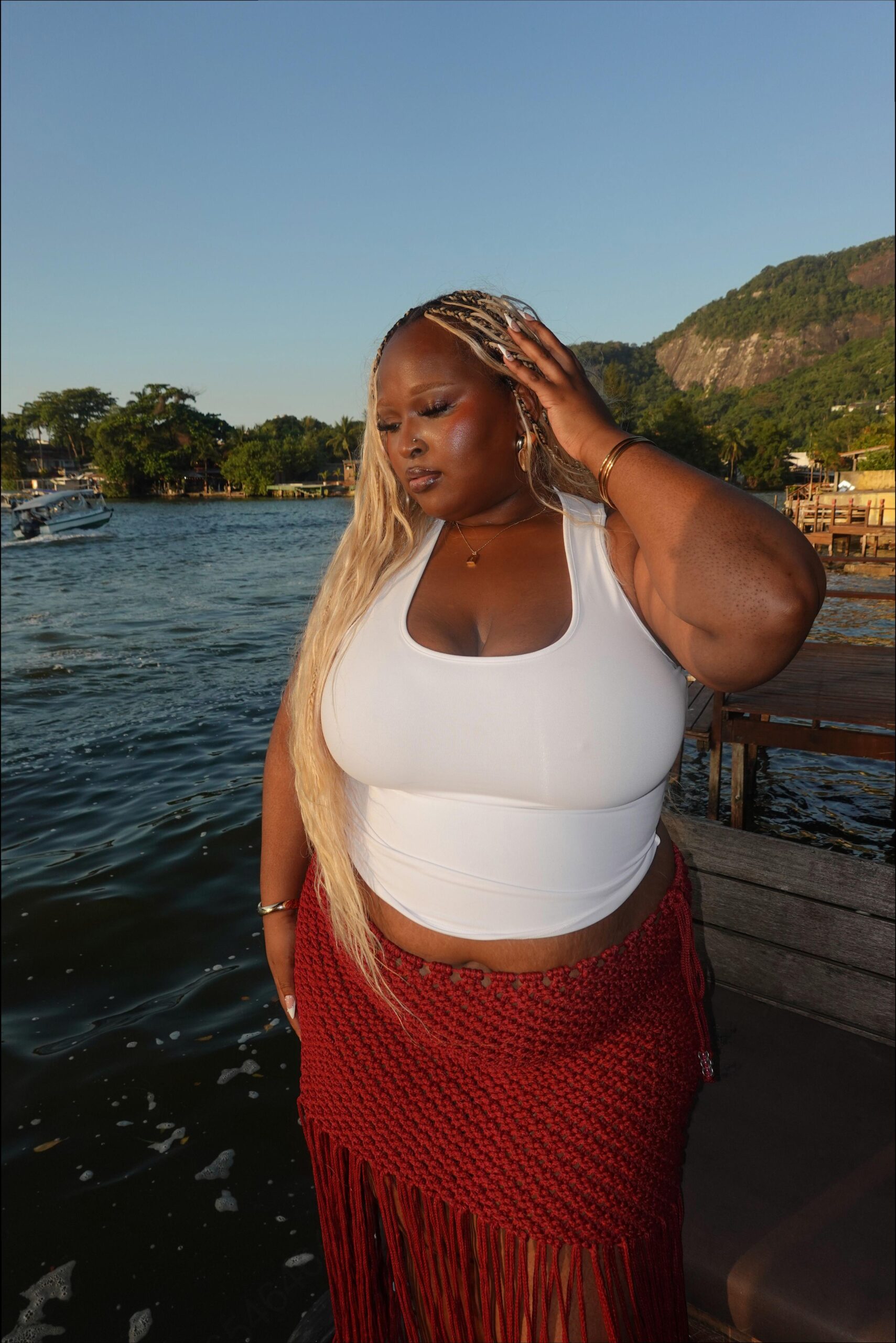 a woman in a red dress standing on a pier