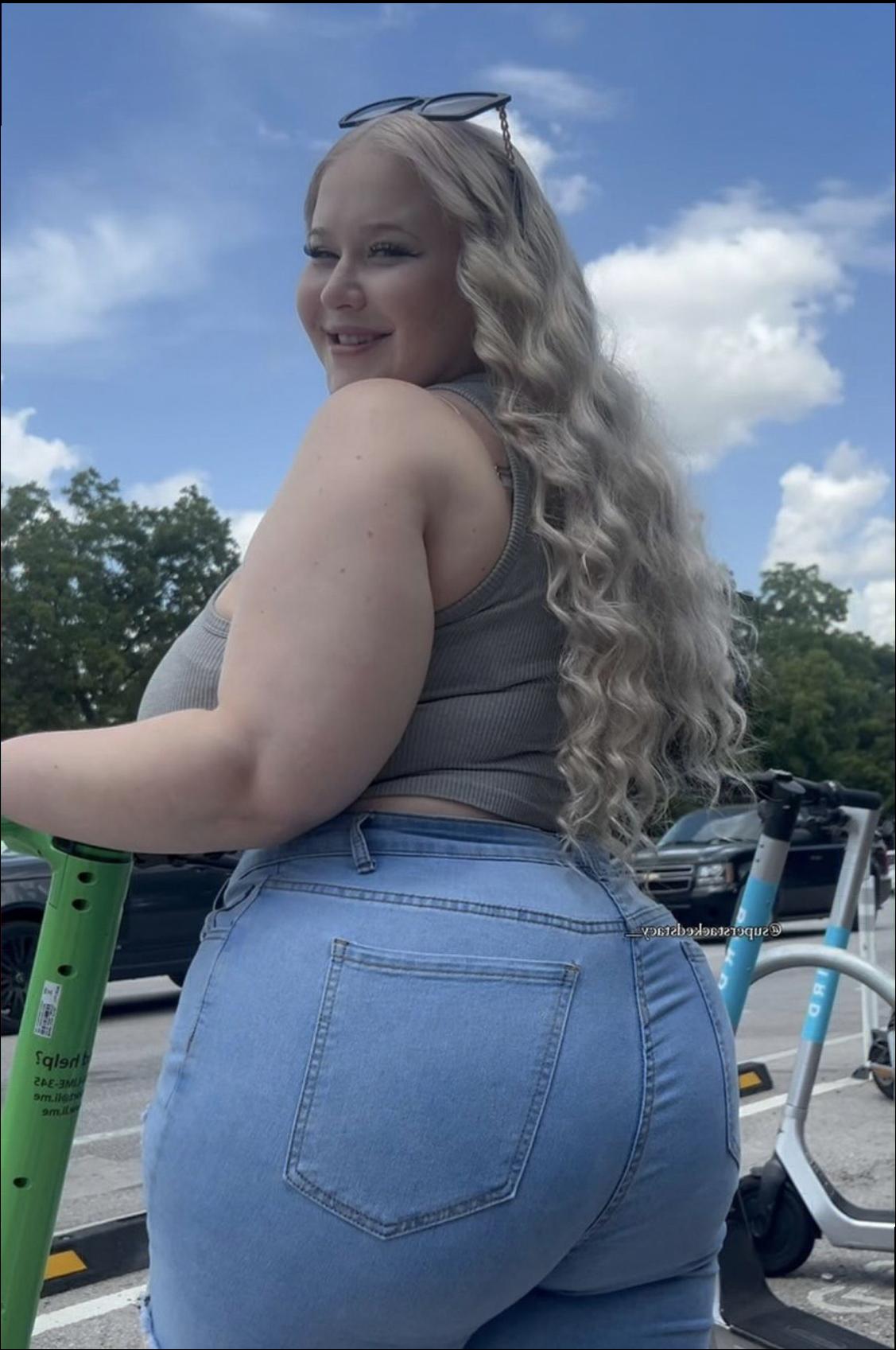 a woman is standing on a bench with a blue and white polka dot umbrella
