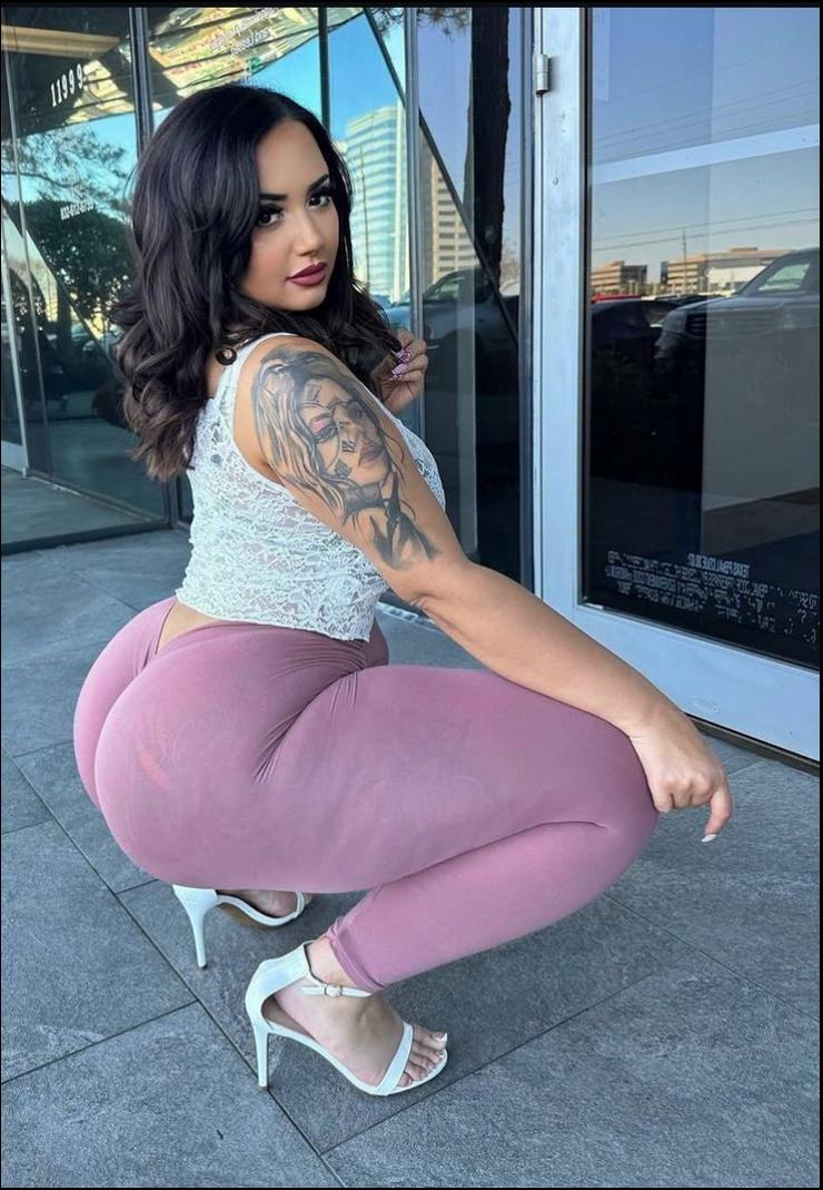 a woman is sitting on a sidewalk with a pink and white polka dot skirt