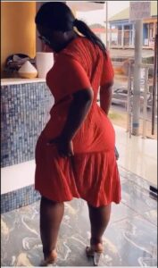 a woman in a red dress standing in front of a wall