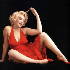 a woman is sitting on a bed with a red towel