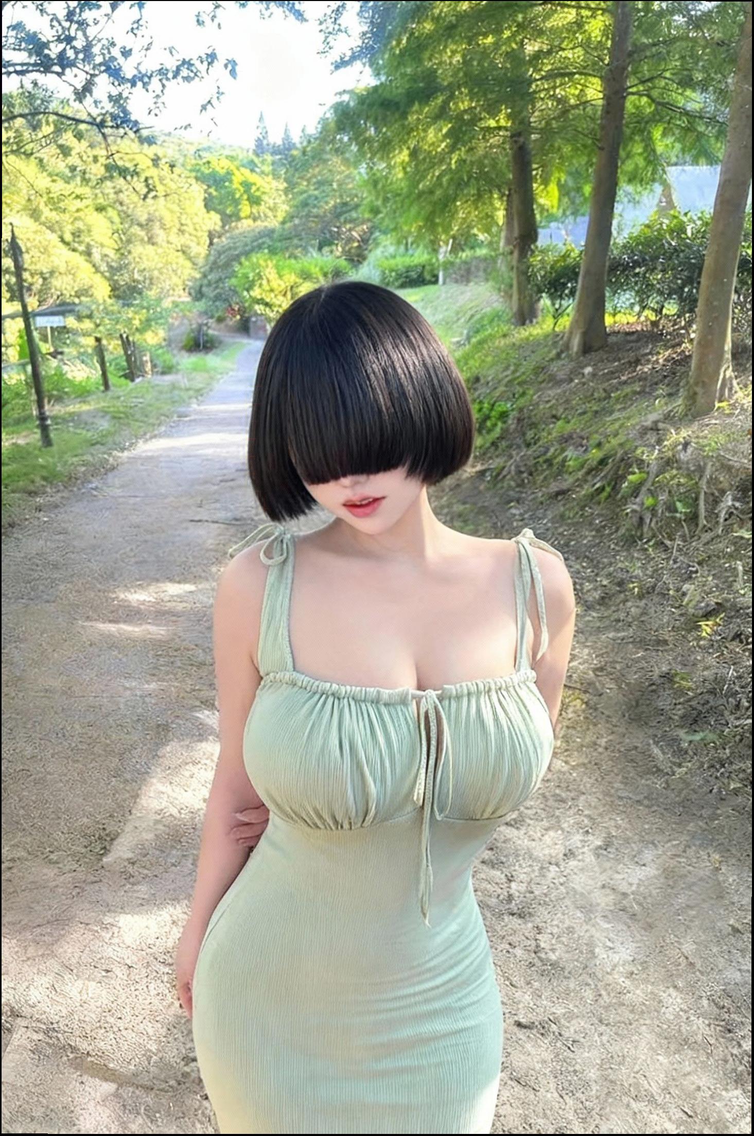 a woman in a black dress standing on a dirt road