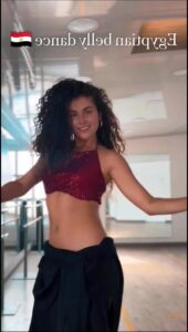 a woman in a black dress is posing for a picture