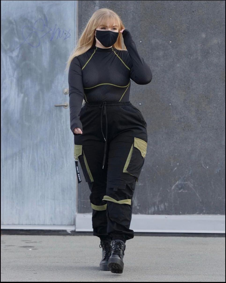 a woman in a black dress and black boots is walking