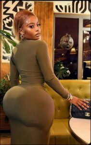 a woman in a black dress sitting on a couch