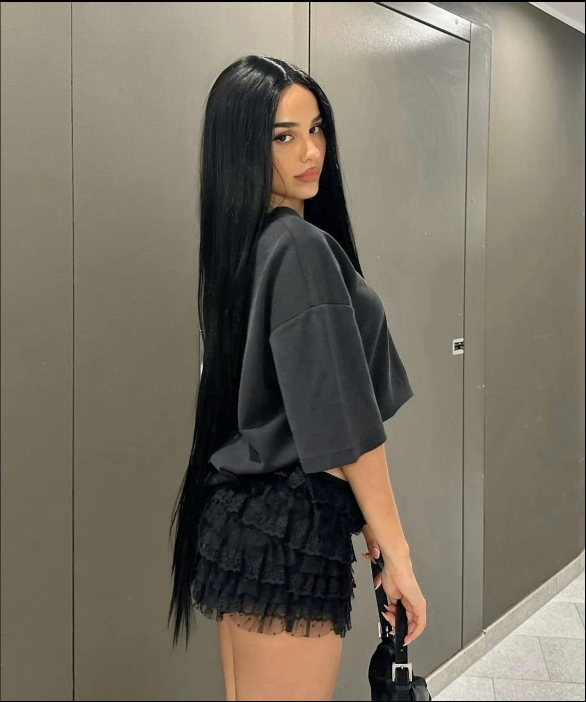 a woman in a black dress and a black purse