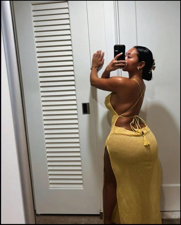 a woman in a white dress is taking a picture