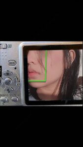 a woman is looking at a camera with a picture of a cat