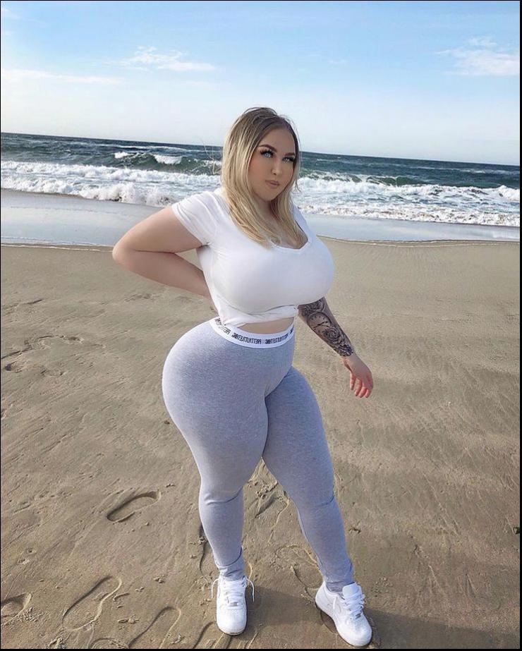 a woman is standing on a beach with a surfboard