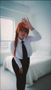 a woman in a suit and tie standing on a bed