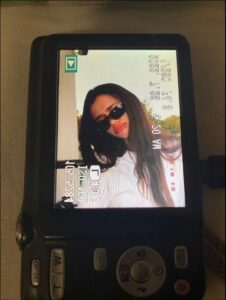 A digital camera displays a video recording of a young woman wearing sunglasses. She is positioned in front of a blurred outdoor background. The video's timestamp indicates the date and time as 2022-07-29 5:20 AM.