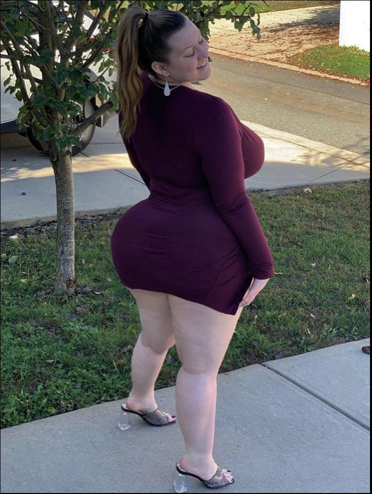 a woman is standing on a sidewalk with a red umbrella