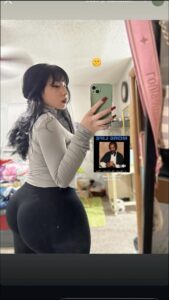 a woman is holding a cell phone and looking at a picture