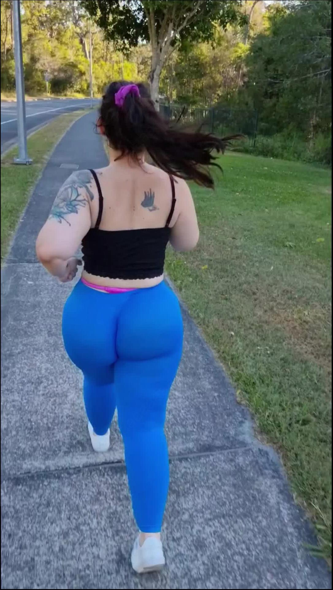 a woman in a pink dress is standing on a sidewalk