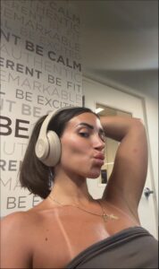 a woman is sitting on a wall and talking on a cell phone