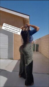 a woman is standing outside with a sign