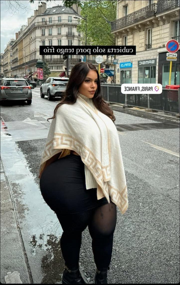 a woman is standing in the street with a sign