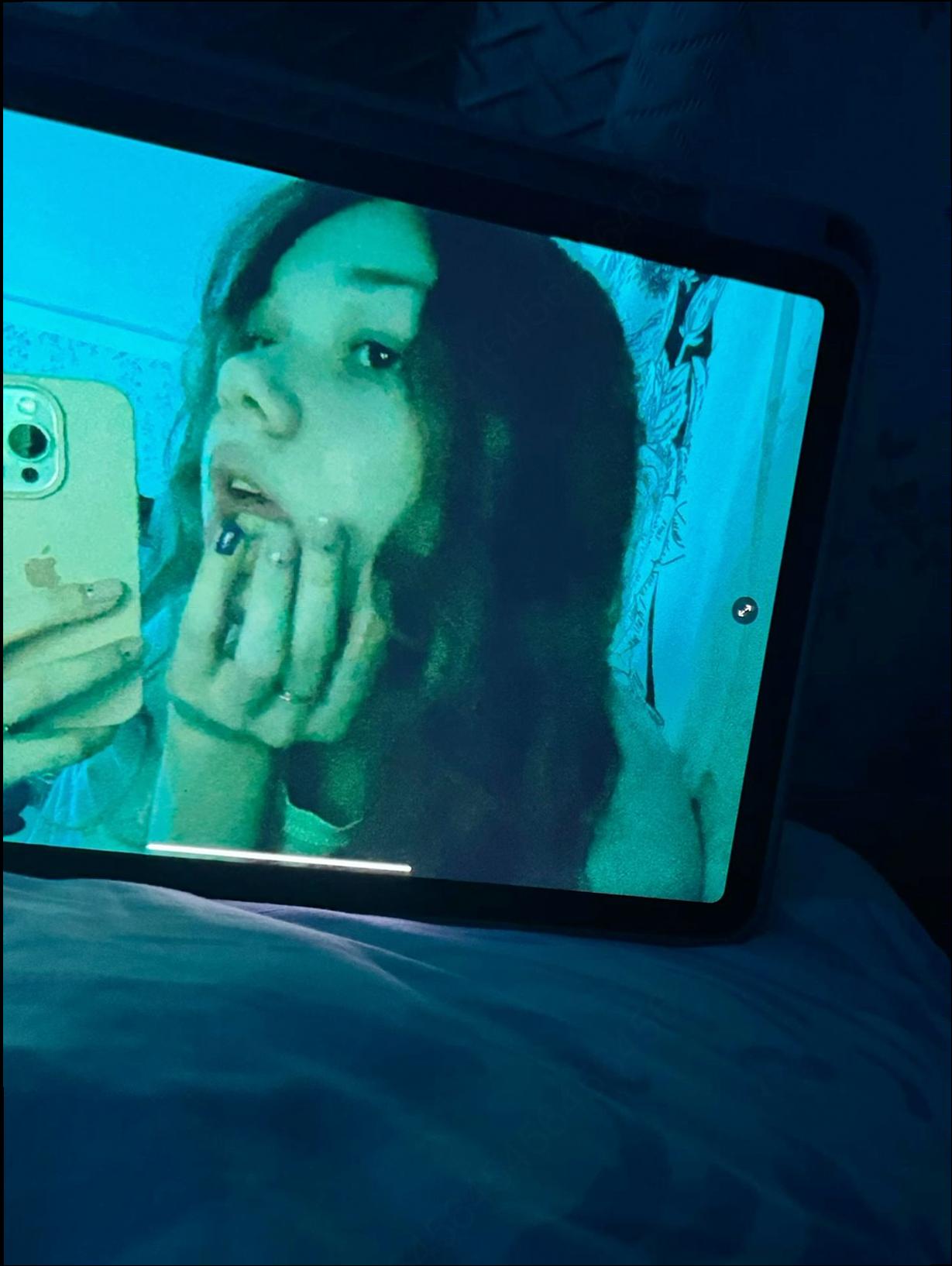 a woman is looking at a cell phone while on a cell phone