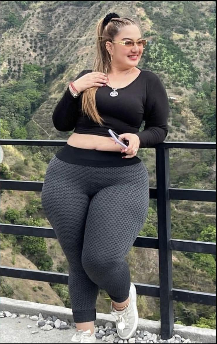 a woman is sitting on a ledge and looking at her cell phone